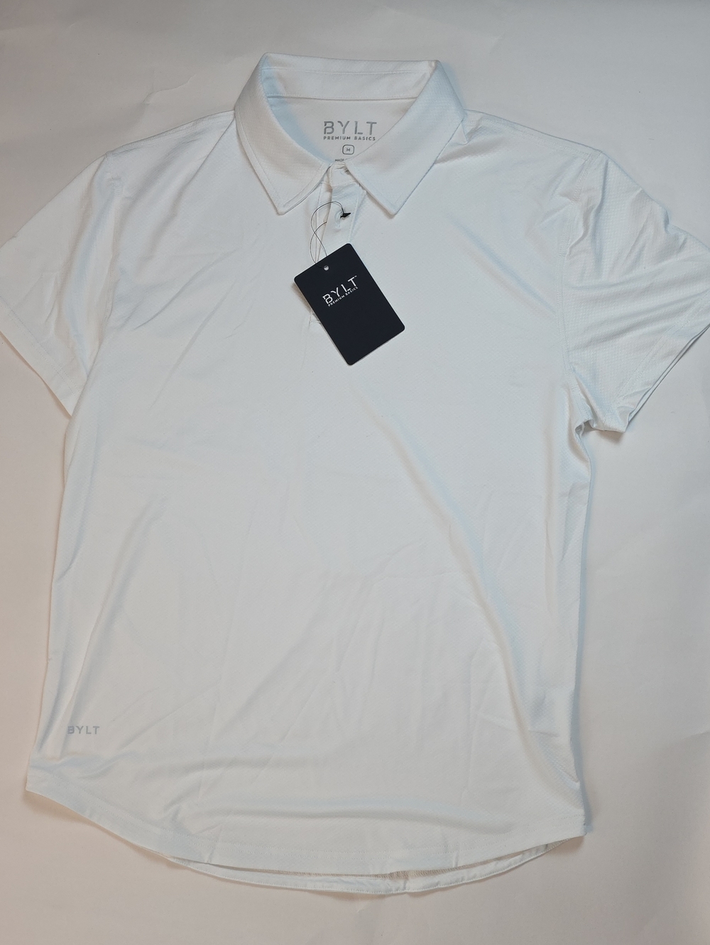NWT Men's BYLT Premium Basics Performance Polo" S/S. Size Medium. Color White.